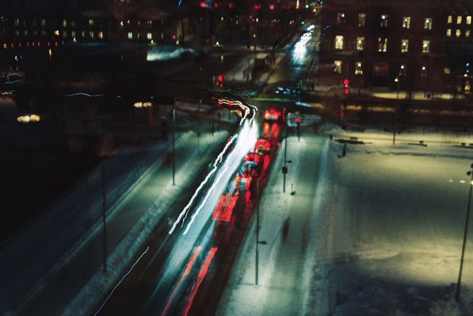 Verschneite Straße bei Nacht mit Lichtspuren des Verkehrs