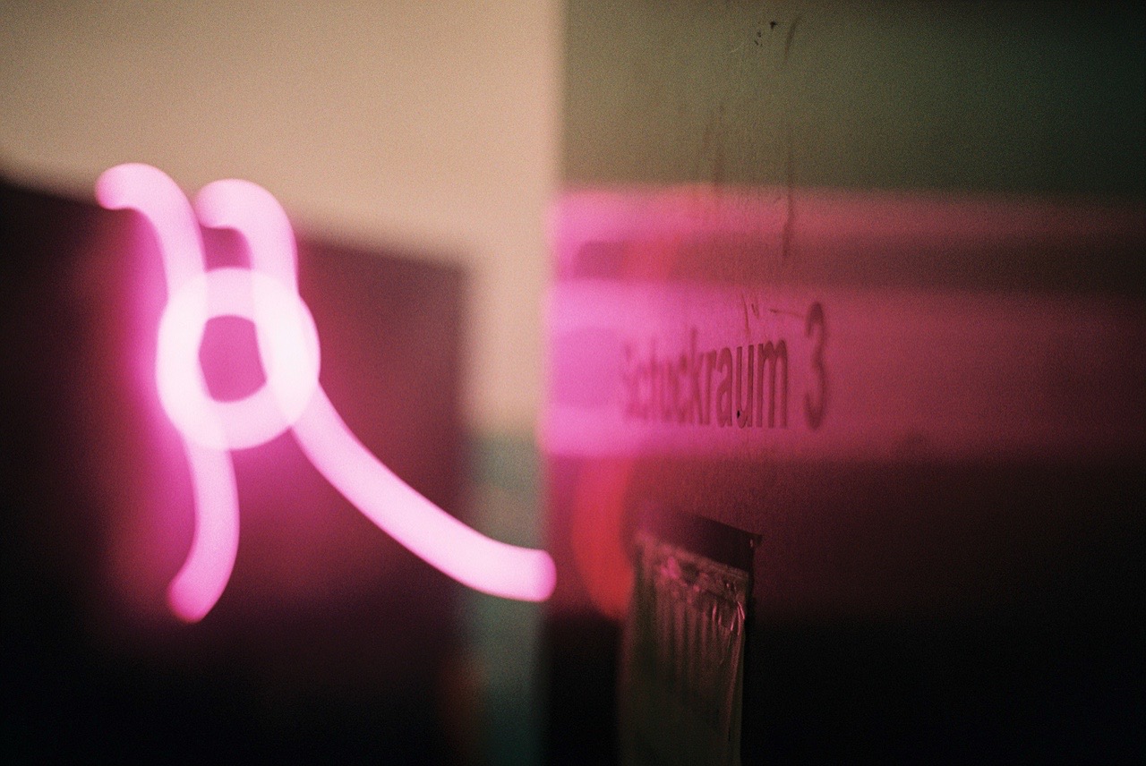 Pinke Lichtspur vor einer Wand mit der Aufschrift „Schutzraum 3“